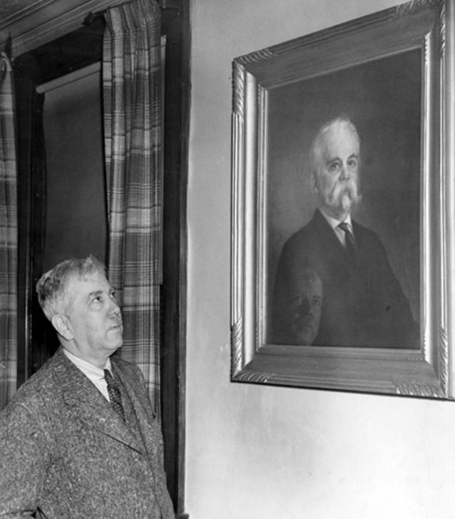 Omar looking at a portrait of his father, Ernst Mueller